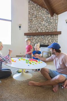 a group of people sitting around a white table with candy on it and one man holding a child