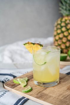 a pineapple and lime drink on a cutting board