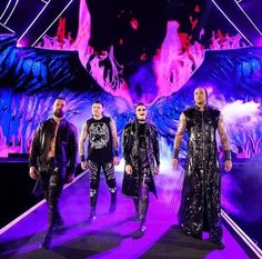 three men in leather outfits standing on stage