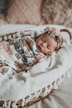 a baby is sleeping in a basket on a bed