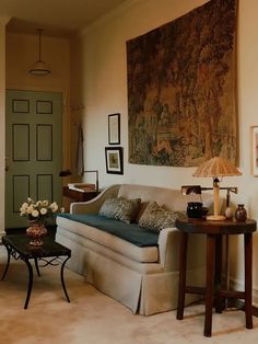 a living room filled with furniture and a painting on the wall above it's door