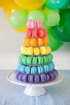 a stack of colorful macaroons sitting on top of a cake