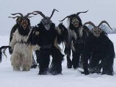 several horned men are walking in the snow with long horns on their heads and beards