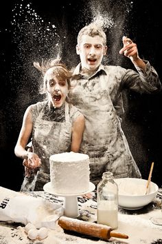 an old photo of two people in front of a cake with sprinkles on it