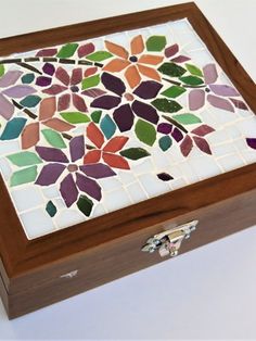 a wooden box with colorful tiles in the shape of flowers on it's lid