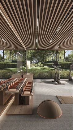 a room filled with lots of wooden benches next to a wall covered in grass and trees