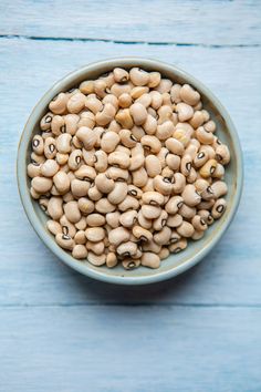 a bowl filled with beans on top of a blue table