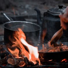 a person cooking food over an open fire