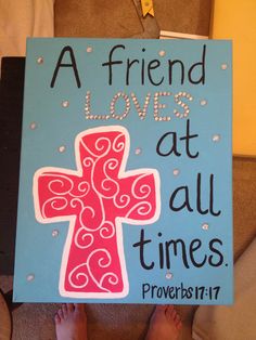 a sign that says a friend loves at all times with a pink cross on it