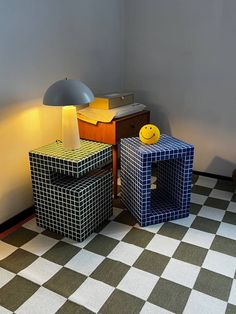 three cube shaped lamps sitting on top of a checkered floor next to a lamp shade