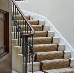 a staircase with carpeted steps leading up to the door and window in the background