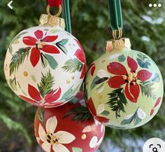 three christmas ornaments hanging from a green string with red and white poinsettis on them