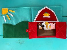 a felt farm scene with pigs, cows and french fries in a red barn door