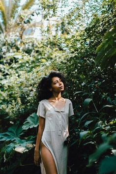 a woman standing in the woods with her eyes closed