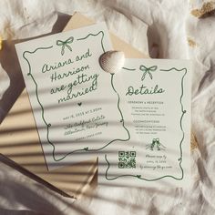 the wedding stationery is laid out on top of each other, with a seashell in the center