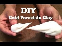 two hands holding small white objects on top of a wooden table with the words diy cold porcelain clay