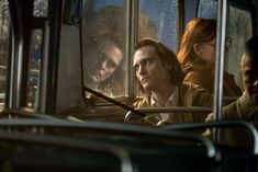 people sitting on a bus looking out the window