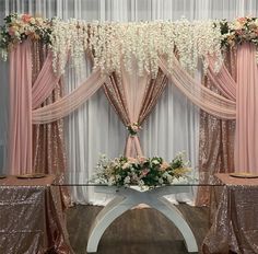 an elegant wedding setup with pink drapes and white flowers