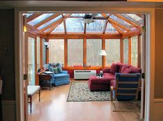 a living room filled with furniture and a large window covered in wood shinnings