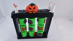 a halloween decoration made out of green plastic tubes and fake pumpkins on the top