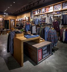 the inside of a clothing store with clothes on display