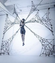 a woman is suspended in the air by wires