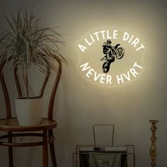 there is a neon sign that says little dirt never hyrt on the wall