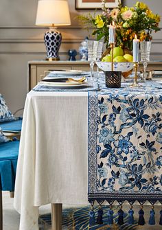 a blue and white table cloth with tassels on it in a dining room