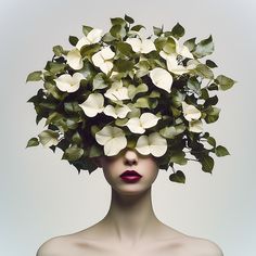 a woman's head with white flowers on it and leaves in the middle of her face