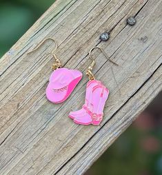 A pair of cowgirl earrings that perfectly captures the essence of the Wild West. These earrings are more than just jewelry; they're a statement piece for any cowgirl at heart. Crafted with intricate details, these earrings feature tiny cowboy boots and a charming hat, exuding a rustic charm that resonates with the adventurous spirit of the cowgirl lifestyle. Whether you're a country aficionado or simply love unique accessories, these cowgirl earrings are sure to add a touch of Western flair to your outfit. Put them on, and instantly feel like you're ready to saddle up and take on the day with a hint of frontier style. Embrace your inner cowgirl with these earrings that blend fashion with a hint of rugged allure. *Gold hardware ear hooks are made of stainless steel *The cow charms are made Pink Cowgirl Accessories, Cowgirl Jewelry Earrings, Cowgirl Boot Jewelry, Cowboy Boots Earrings, Country Western Fashion, Cowgirl Hat Earrings Pink, Mode Country, Rodeo Cowgirl, Cowgirl Accessories