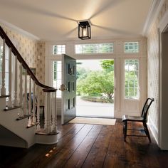 an open door leading to a foyer with wooden floors