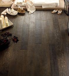 a bedroom with wood floors and candles on the floor