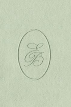 the monogrammed logo is etched on paper and has a circular frame with an e in it