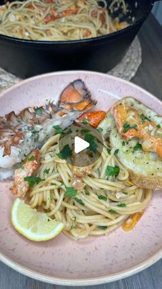 a plate with pasta, shrimp and garlic bread on it