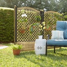 a blue chair sitting in the grass next to a white vase with flowers on it