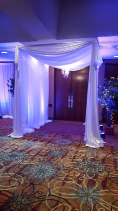 a room decorated with white drapes and flowers