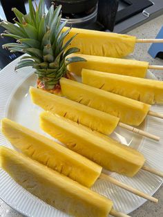 pineapple slices on a plate with toothpicks attached to them, ready to be eaten