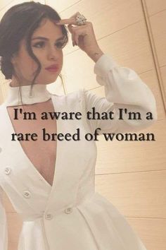 a woman wearing a white dress with the words i'm aware that i'm a rare breed of woman