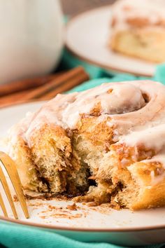 a cinnamon roll on a plate with a fork