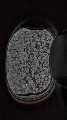 an airplane window with some snow on it