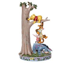 winnie the pooh and tigger figurine sitting on top of a tree