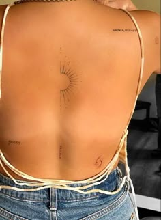 the back of a woman's body with tattoos on her upper and lower back