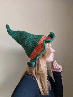 a woman wearing a crocheted green and orange hat