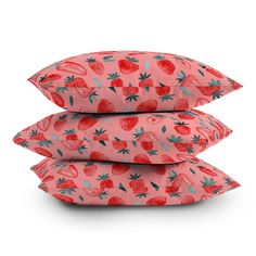 three pillows stacked on top of each other with strawberries and leaves printed on them