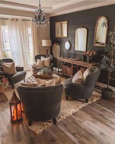 a living room filled with furniture and a chandelier hanging from the ceiling over a wooden floor