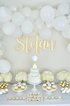 a table topped with cake and desserts next to balloons