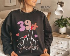 "I Am 39+ Middle Finger Sweatshirt, Personalized 40th Birthday Sweater, Custom 1984 Birthday Party Shirt, Funny I Am 39 Plus Tshirt, 40 Bday HOW TO ORDER ➀ Select color ➁ Select the size (Please check size chart) ✦ True to size. Size up 1-2 sizes for an oversized look. ➂ Add to cart ✦ (Optional) \"Add message to Seller\" on the checkout page. GARMENT FEATURES ✦ Crew neckline ✦ Direct to garment printing - no vinyl, decal, or iron-on technique ✦ Our designs are printed on the garment to last a lo Birthday Long Sleeve Sweatshirt With Lettering, Birthday Embroidered Text T-shirt With Crew Neck, Birthday Crew Neck T-shirt With Embroidered Text, Birthday Custom Print Crew Neck T-shirt, Novelty Birthday T-shirt With Crew Neck, Birthday Sweater, Birthday Party Shirt, Party Shirts, Funny Me