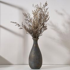 a vase filled with dried flowers on top of a table