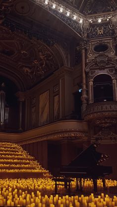 an auditorium filled with candles and a grand piano