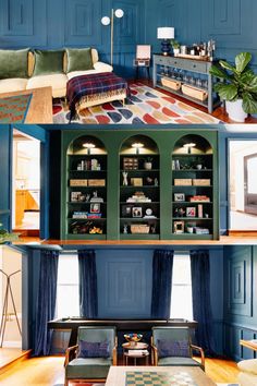 the inside of a living room with blue walls and wood flooring, bookshelves in